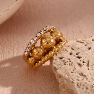 Macro view of gold plated triple layer ring with crystal stones and twisted texture details