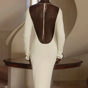 Detalle artístico del vestido de punto blanco con espalda abierta y puños negros