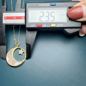 Detailed measurement of gold crescent moon pendant with shell inlay and star, 23.5mm size