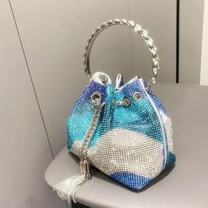 Dettaglio della borsa a secchiello con strass sfumati blu e argento e manico in metallo