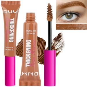 Macro shot of DNM thickening brow mascara brush with hair-like fibers and creamy texture