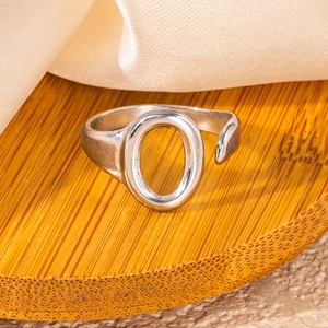Macro shot of silver titanium steel open ring featuring a hollow oval letter O design
