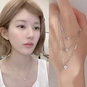 Detailed views of a round zircon solitaire pendant necklace shown on a model neck