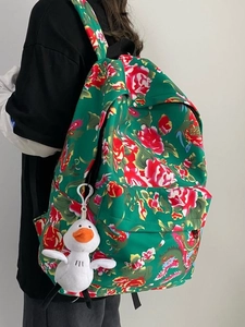 Ethnic backpack with green traditional floral pattern and plush duck pendant on model