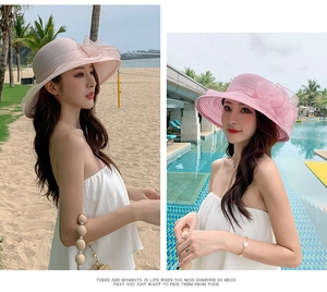 Pink beach hat with organza floral detail shown in outdoor beach and pool settings