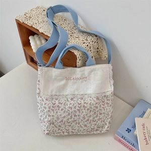 Detailed view of pastoral floral canvas tote bag with pink embroidery and white lace trim