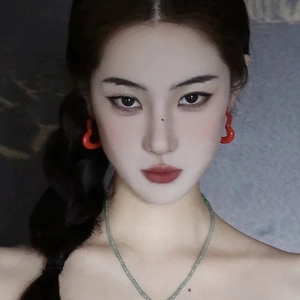 Fashionable red heart drop earrings paired with a thin light green beaded necklace