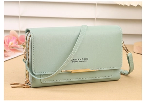 Detail view of mint green crossbody phone bag with gold metal trim and litchi texture
