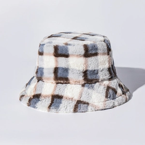 Détail de la texture en fausse fourrure douce sur un chapeau bob à carreaux d'hiver