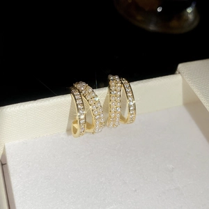 Dettaglio macro di orecchini a C placcati in oro 14k con perle e zirconi brillanti