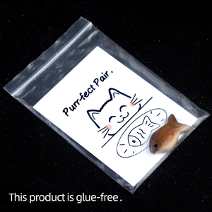 Purr-fect Pair wooden fish toy with cat card in a clear pouch on black background