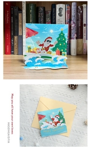 Detailed 3D pop-up Christmas card featuring a surfing Santa with a matching envelope