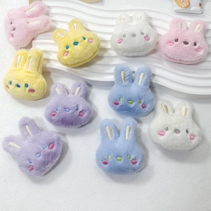 Detail of plush bunny brooches in macaron colors with embroidery and soft faux fur texture