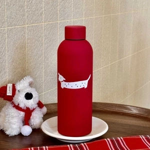 Detail of red matte stainless steel bottle with a cute white dachshund illustration