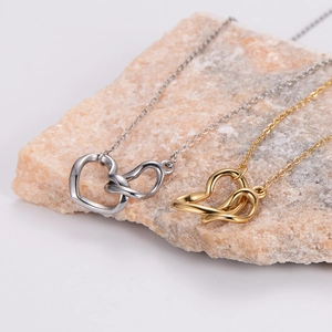 Polished stainless steel necklaces with interlocking heart knot pendants in gold and silver