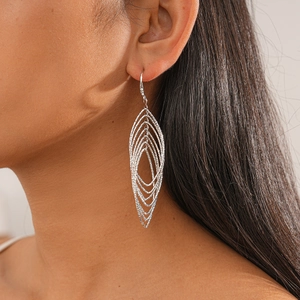 Close-up of silver multilayer geometric leaf-shaped earrings on model with high gloss finish