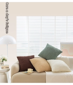 Detail of soft 3D bubble textured decorative pillows in earth tone colors on a sofa