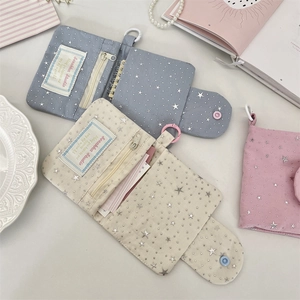 Detail of star pattern canvas tri-fold wallet with zipper pocket and clear ID slot