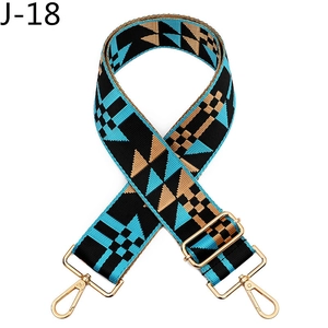 Detail of geometric pattern woven bag strap with golden metal buckle and lobster clasp