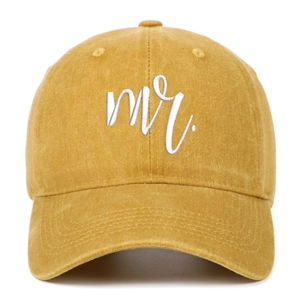 Detailed view of white 'mr.' 3D embroidery on a mustard yellow vintage washed baseball cap