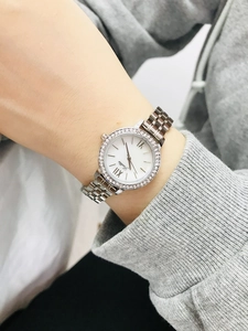 Close-up of Scottie silver watch with diamond bezel and mother-of-pearl dial detail