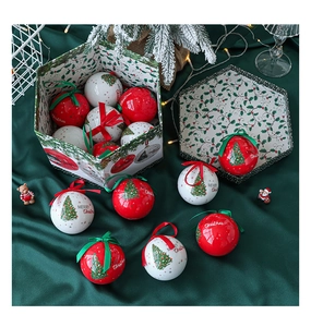 Close-up of red and white Christmas baubles with Merry Christmas text in a gift box