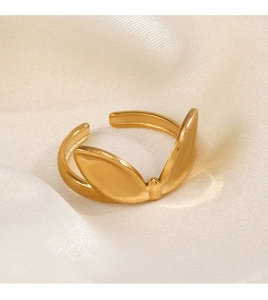 Detailed macro view of a gold rabbit ear open ring on elegant white silk fabric