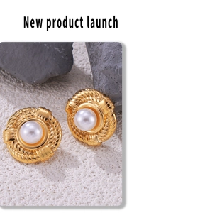 Detailed macro shot of vintage gold twist earrings with inlaid pearl on rock decor
