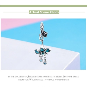 Macro detail of S925 silver blue enamel flower pendant with dangling zircon crystals