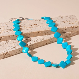 Elegante collana in acciaio inossidabile con perle quadrate blu su fondo in pietra