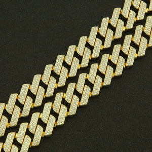 Macro detail of gold Cuban link bracelets encrusted with sparkling rhinestones in hip hop style