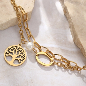 Gold double-layer tree of life bracelet with white pearl on natural stone background