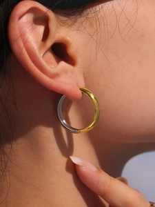 Close-up of dual-tone gold and silver hoops showing 18k gold plating on model