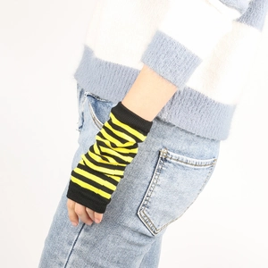 Close-up of black and yellow striped knitted arm sleeves on a model's wrist and arm