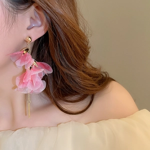 Détail de boucles d'oreilles pétales en mousseline rose avec longue chaîne dorée