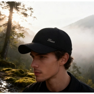 Close-up of black baseball cap with Teans metal logo and textured diamond pattern