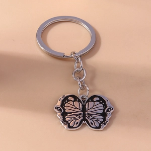 Detailed close-up of a butterfly metal pendant with black and silver wing textures