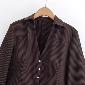 Detailed view of the dark brown vertical pinstripe fabric and high-quality tailoring