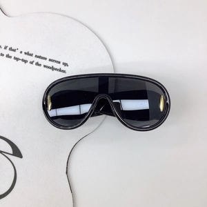 Détail de lunettes de soleil masque avec verres noirs et décorations dorées sur les bords