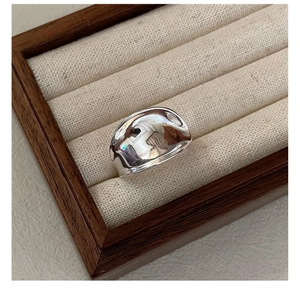 Macro shot of an irregular wide silver saddle ring with a high-polished mirror finish