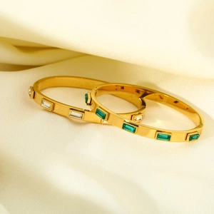 Detailed view of gold plated stainless steel bangles with green and white zircon stones