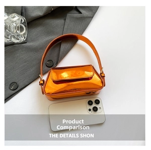 Size comparison of vibrant orange patent leather baguette bag next to a smartphone