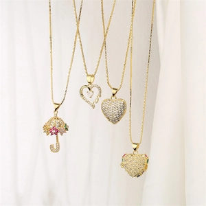 Detail of gold necklaces featuring heart and umbrella pendants with cubic zirconia