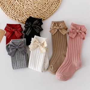 Spanish style Christmas red baby socks with gold thread bow and ribbed knit texture