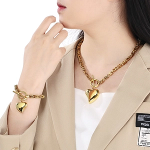 Exaggerated gold titanium steel necklace and bracelet set with hollow heart pendant and OT buckle