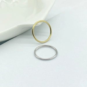 Detailed view of minimalist gold and silver stacked thin band rings on white background