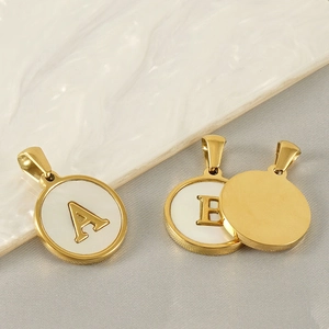Detailed macro view of 18k gold letter A and B pendants with white inlay detail