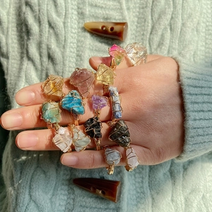 Detail of handmade wire wrapped citrine and crystal rings set on a model's hand
