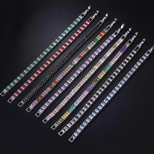 Macro display of ten colorful rectangular baguette cut zircon tennis bracelets on black surface
