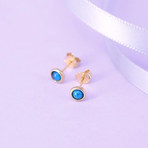 Detail showing deep blue round gemstones set in elegant gold flower moon stud earrings